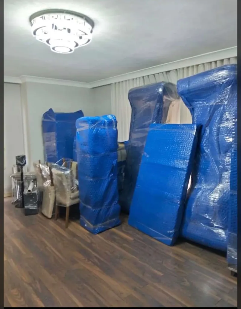 Salonda paketlenmiş mobilyalar ve streçlenmiş sandalyeler